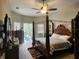 A cozy main bedroom featuring a four-poster bed and access to the outdoor pool area at 10532 Cory Lake Dr, Tampa, FL 33647
