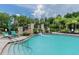 Community pool featuring a water slide, lounge chairs, and tropical landscaping at 10532 Cory Lake Dr, Tampa, FL 33647