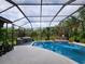 Beautiful backyard pool area with a screened enclosure, outdoor kitchen, and lush landscaping at 10532 Cory Lake Dr, Tampa, FL 33647