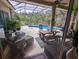 Relaxing screened-in pool area with an outdoor dining table and comfortable lounge furniture at 10532 Cory Lake Dr, Tampa, FL 33647