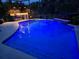 Beautiful pool at night with underwater lights and an outdoor kitchen at 10532 Cory Lake Dr, Tampa, FL 33647