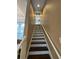 Bright stairway with a neutral color palette and white railings leading to the upper level of the home at 10532 Cory Lake Dr, Tampa, FL 33647