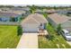 Aerial view of a well-maintained single-story home with a two-car garage, manicured lawn, and beautiful landscaping at 10945 High Noon Trl, Parrish, FL 34219