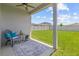 Spacious backyard with lush green grass, privacy fence, and a covered patio area at 10945 High Noon Trl, Parrish, FL 34219