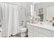Well-lit bathroom with white vanity, shower/tub combination with white shower curtain, and decorative accents at 10945 High Noon Trl, Parrish, FL 34219