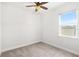 Cozy bedroom with neutral carpet, ceiling fan, and ample natural light from window at 10945 High Noon Trl, Parrish, FL 34219