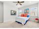 Inviting bedroom with a comfortable bed, two windows, and colorful artwork on the walls at 10945 High Noon Trl, Parrish, FL 34219