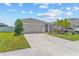 Exterior view of a well-maintained single Gathering home with a paved driveway and lush landscaping at 10945 High Noon Trl, Parrish, FL 34219