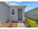 Inviting front entrance with a light blue door, rock landscaping, and pathway at 10945 High Noon Trl, Parrish, FL 34219