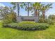 Community sign surrounded by landscaped greenery and towering palm trees at 10945 High Noon Trl, Parrish, FL 34219