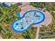 Aerial view of a playful splash pad featuring water features, slides, and a seating area with lounge chairs at 10945 High Noon Trl, Parrish, FL 34219