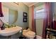Cozy half bathroom featuring a vintage style sink, toilet, and cute decorations under the round mirror at 1156 2Nd S Ave, Tierra Verde, FL 33715