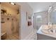 Bright bathroom featuring double sinks, an arched window, and an adjacent shower stall at 1156 2Nd S Ave, Tierra Verde, FL 33715