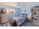 Comfortable bedroom featuring blue walls, a ceiling fan, and a quaint window at 1156 2Nd S Ave, Tierra Verde, FL 33715