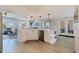 Open-concept kitchen with an island, white cabinets, and stainless steel dishwasher and sink at 1156 2Nd S Ave, Tierra Verde, FL 33715