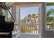 A view from the living space showcasing the outdoor scenery and lush greenery beyond the balcony at 1156 2Nd S Ave, Tierra Verde, FL 33715