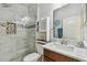 Updated bathroom featuring marble tile, glass shower, and wooden vanity for a modern look at 11602 Sunburst Marble Rd, Riverview, FL 33579