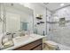 Bathroom with a marble countertop vanity and tiled walk-in shower with glass door at 11602 Sunburst Marble Rd, Riverview, FL 33579