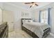 Bright bedroom features marble tile floors, ceiling fan, and a large comfortable bed with drawer storage at 11602 Sunburst Marble Rd, Riverview, FL 33579