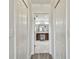 Hallway view into bathroom showing white marble floors and dark brown vanity at 11602 Sunburst Marble Rd, Riverview, FL 33579
