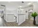 Hallway with gray wood floors, leading to multiple rooms and featuring a large potted plant at 11602 Sunburst Marble Rd, Riverview, FL 33579