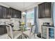 Breakfast nook with modern table and decorative chairs, set next to black cabinets and stainless steel wine fridge at 11602 Sunburst Marble Rd, Riverview, FL 33579