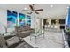 Bright living room featuring marble floors, modern abstract art, and a contemporary ceiling fan, flowing into the open kitchen at 11602 Sunburst Marble Rd, Riverview, FL 33579