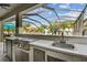 Outdoor kitchen with countertop, grill and cabinetry in a screened-in patio at 11602 Sunburst Marble Rd, Riverview, FL 33579