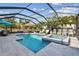 Sparkling pool and spa surrounded by patio and lounge chairs, all under a screened enclosure at 11602 Sunburst Marble Rd, Riverview, FL 33579