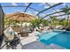 Gorgeous screened pool with lounge seating, an umbrella, and a spa surrounded by lush, tropical landscaping at 11602 Sunburst Marble Rd, Riverview, FL 33579