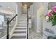 Bright stairway with modern white and gray wood steps and a glass table next to the entranceway at 11602 Sunburst Marble Rd, Riverview, FL 33579
