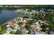 Wide aerial view of lakeside neighborhood, showcasing homes with manicured lawns and mature trees along the shoreline at 11641 Branch Mooring Dr, Tampa, FL 33635
