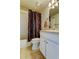 The bathroom features a white vanity with sink, toilet, and a tub with a shower curtain at 11641 Branch Mooring Dr, Tampa, FL 33635