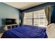 Bedroom with blue walls and a large window with bright natural light at 11641 Branch Mooring Dr, Tampa, FL 33635