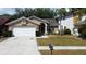 Charming home exterior with a well-manicured lawn and a two-car garage at 11641 Branch Mooring Dr, Tampa, FL 33635
