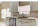 Well-lit kitchen featuring white cabinets, stainless steel dishwasher and sink at 11641 Branch Mooring Dr, Tampa, FL 33635
