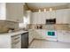 Modern kitchen with white cabinets, stainless steel appliances, and tile backsplash at 11641 Branch Mooring Dr, Tampa, FL 33635