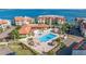 Aerial view of the community pool and spa surrounded by tropical landscaping and several condo buildings at 120 1St E St # 109, Tierra Verde, FL 33715