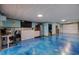 Finished basement with blue epoxy floors, an office, and a garage door at 120 1St E St # 109, Tierra Verde, FL 33715