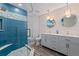 Bathroom featuring a double vanity with modern lighting, plank flooring, and large shower with blue accent tile at 120 1St E St # 109, Tierra Verde, FL 33715