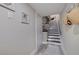 Hallway leading to stairs features white-painted walls, modern wall art, and wood-look floors at 120 1St E St # 109, Tierra Verde, FL 33715