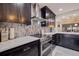 A modern kitchen featuring sleek dark cabinets, stainless steel appliances and beautiful backsplash at 120 1St E St # 109, Tierra Verde, FL 33715