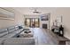 Living room with a modern sofa, decorative ottoman, wood floors, and sliding doors to a balcony at 120 1St E St # 109, Tierra Verde, FL 33715