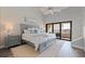 A serene bedroom featuring a gray headboard bed, ceiling fan, and balcony access with views at 120 1St E St # 109, Tierra Verde, FL 33715