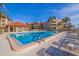 Community pool surrounded by lounge chairs and palm trees, with condo buildings in the background at 120 1St E St # 109, Tierra Verde, FL 33715