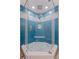 Bright shower featuring stylish blue tile with white pebble accents, rainfall shower head, and glass enclosure at 120 1St E St # 109, Tierra Verde, FL 33715