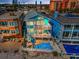 Beautiful aerial view of a house with a pool and balconies overlooking white sand and ocean at 13303 Gulf Ln, Madeira Beach, FL 33708