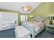 Bright bedroom with a ceiling fan, balcony access and comfortable bed and beach themed bedding at 13303 Gulf Ln, Madeira Beach, FL 33708