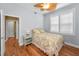 Bright bedroom with hardwood floors, floral bedding, and natural light from a window at 13303 Gulf Ln, Madeira Beach, FL 33708