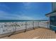 Spacious wooden deck with white railing offers stunning views of the ocean and beach at 13303 Gulf Ln, Madeira Beach, FL 33708